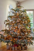 Grand arbre de Noël décoré avec des guirlandes et des cadeaux