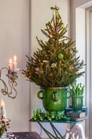 Petit arbre de Noël en pot vert vintage entouré de bougies chauffe-plat