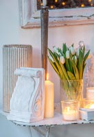 Plâtre décoratif avec vase de tulipes blanches et bougies sur table vintage