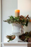 Urne blanche avec décorations de Noël et bougie