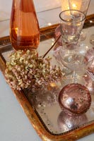 Décorations en bronze et or sur plateau avec verres et fleur d'hortensia séchée