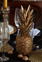 Ananas et noix pulvérisés d'or sur une table à manger classique