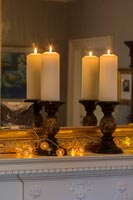 Bougies et guirlandes lumineuses sur cheminée avec miroir