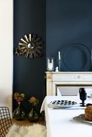 Salle à manger classique avec des murs peints en bleu foncé et un mobilier blanc