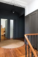 Mur peint en noir et plancher en bois sur un palier classique à l'étage