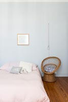 Murs peints en bleu pâle et couvre-lit rose dans la chambre d'enfant classique