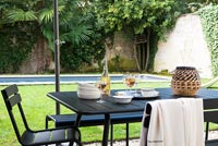 Coin repas extérieur, pelouse et piscine dans jardin clos