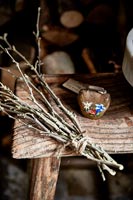 Bouquet de bâtons en bois et cloche décorative sur table en bois rustique