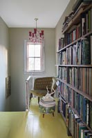 Bibliothèque sur palier à l'étage avec sol peint en jaune