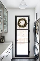 Couronne de Noël sur porte en verre encadrée noire dans la cuisine moderne