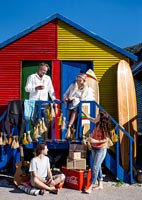 Famille à l'extérieur des cabines de plage colorées