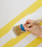 Peinture blanche sur bandes diagonales jaunes sur mur