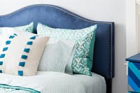 Tête de lit en velours bleu et variété d'oreillers