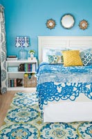Chambre bleue avec mobilier blanc et accessoires à motifs