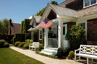 Extérieur de maison avec porche, jardins à la française et drapeau américain