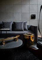 Salon noir et gris avec table et skateboard dorés