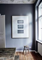 Oeuvre encadrée de blanc sur mur peint gris dans la salle à manger