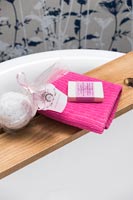 Serviette rose sur étagère de salle de bain en bois avec articles de toilette