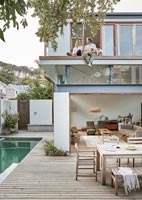 Salon extérieur contemporain avec piscine - couple et chien sur balcon
