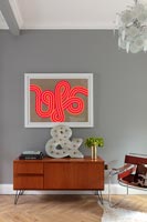 Buffet vintage et œuvres d'art colorées dans le salon moderne