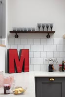Grande lettre rouge 'M' sur le plan de travail de la cuisine moderne