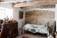 Poutres apparentes et mur de pierre dans une chambre rustique