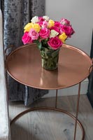 Vase de roses sur table en cuivre