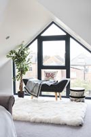Chaise longue en cuir par fenêtre de chambre à coucher moderne