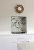 Alcôve recouverte de marbre sur plaque de cuisson avec ventilateur extracteur et horloge