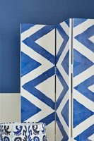 Écran d'intimité bleu et blanc à côté du mur peint dans les mêmes couleurs
