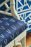 Coussin à motifs bleu et blanc sur chaise en bois peint