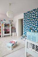Chambre pour enfants avec papier peint imprimé audacieux sur mur caractéristique