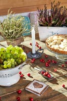 Fruits, baies et bruyère en pot sur la table de la salle à manger rustique