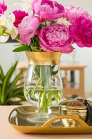 Vase en verre et or plein de fleurs roses et blanches