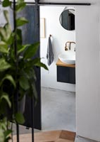 Petite salle de bain monochrome avec sol en béton poli
