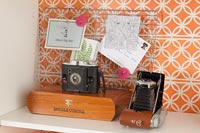 Appareils photo vintage sur étagère bibliothèque avec support papier peint orange