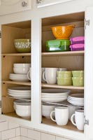 Armoire de cuisine pleine de vaisselle et de boîtes de rangement