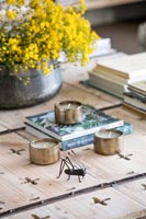 Bug en métal et bougies chauffe-plat sur table basse en bois