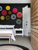 Chambre moderne avec affichage de plaques décoratives en osier sur mur noir