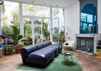 Canapé-divan en cuir dans le salon moderne avec vue sur le jardin de la cour