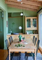 Salle à manger rustique avec murs peints en vert et poutres apparentes