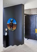 Oeuvre colorée sur mur peint en noir dans le couloir contemporain