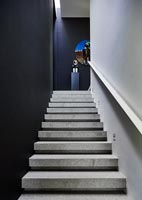 Voir l'escalier en béton avec des murs peints en noir à des illustrations colorées