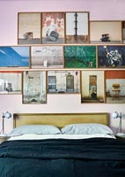 Affichage de photographies encadrées sur un lit dans une chambre moderne