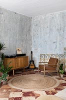 Salon avec mobilier vintage et murs en plâtre nu