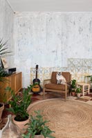 Chat sur fauteuil dans un salon de campagne avec des murs en plâtre nu