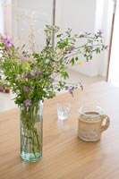Détail d'arrangement de fleurs sauvages dans un vase sur une table en bois
