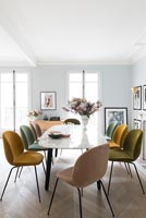 Chaises rembourrées de différentes couleurs autour de la table à manger en marbre vintage