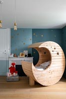 Lit bébé en forme de lune en bois dans la chambre d'enfant moderne