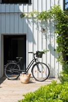 Vélo et panier par porte d'entrée de maison de campagne moderne